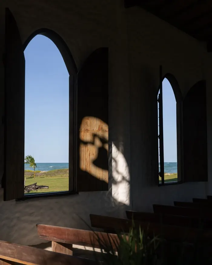 Interior da capela, com janelas em arco abertas para o mar