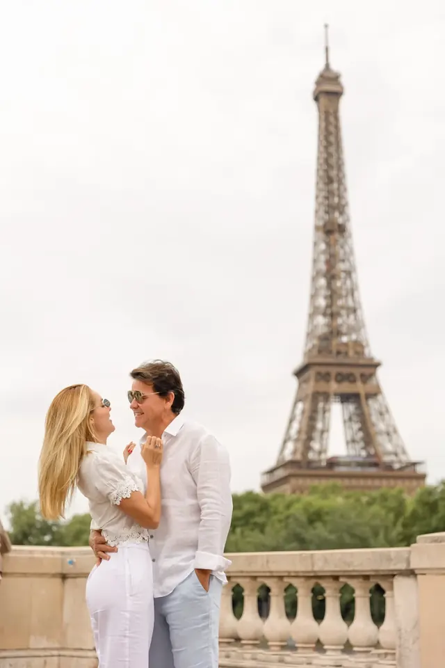Thais e Marcos sorrindo, com a Torre Eiffel ao fundo